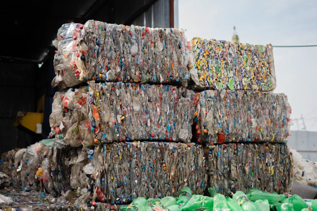 Bales of post consumer plastic bottles stacked at a recycling yard as feedstock for recycled PET